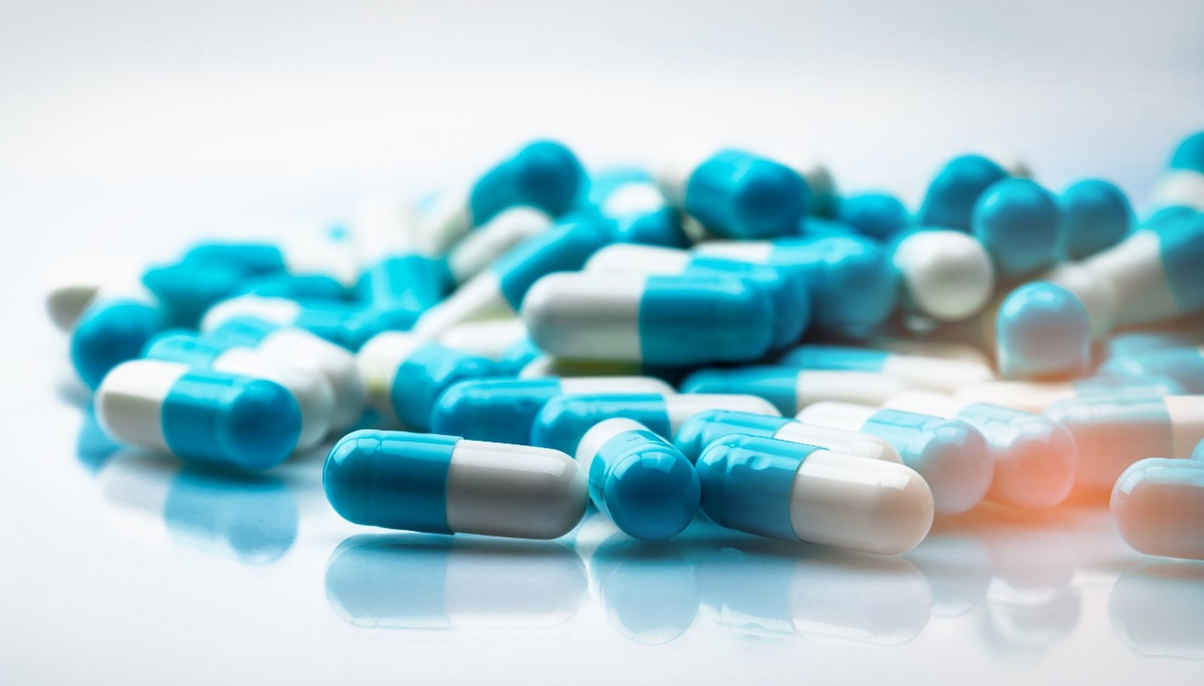 Blue and white capsules on a white table