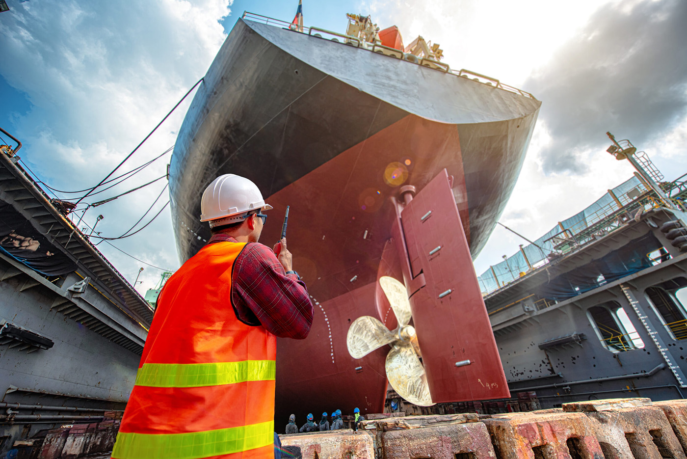 dock worker in front of ship on walkie talkie