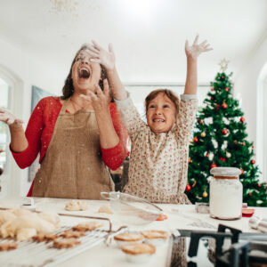 Happy woman and child baking Christmas cookies despite holiday butter shortages.