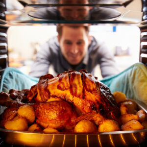 Man Taking Holiday Turkey Out Of The Oven