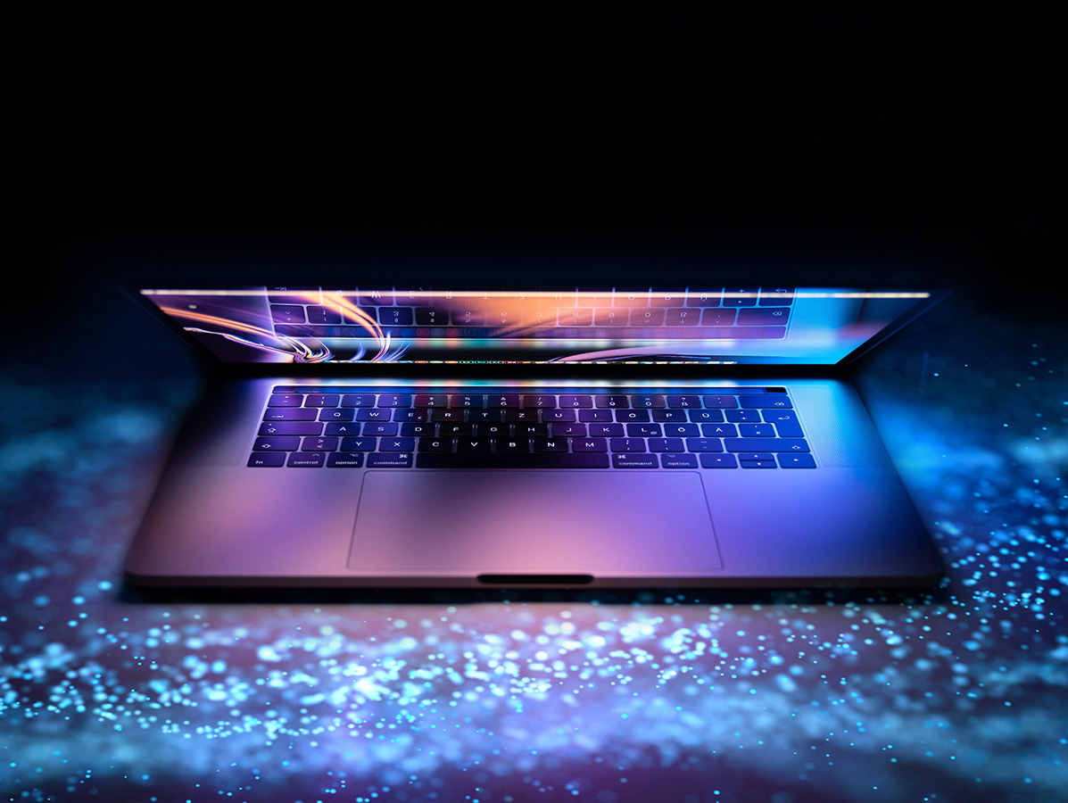 half closed laptop with screen glowing