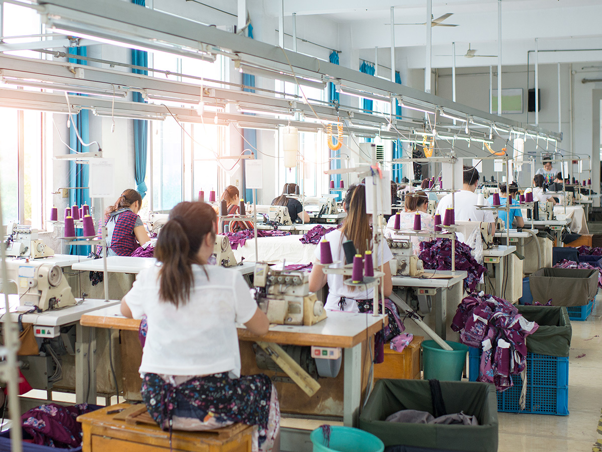 young textile workers working in crowded factory