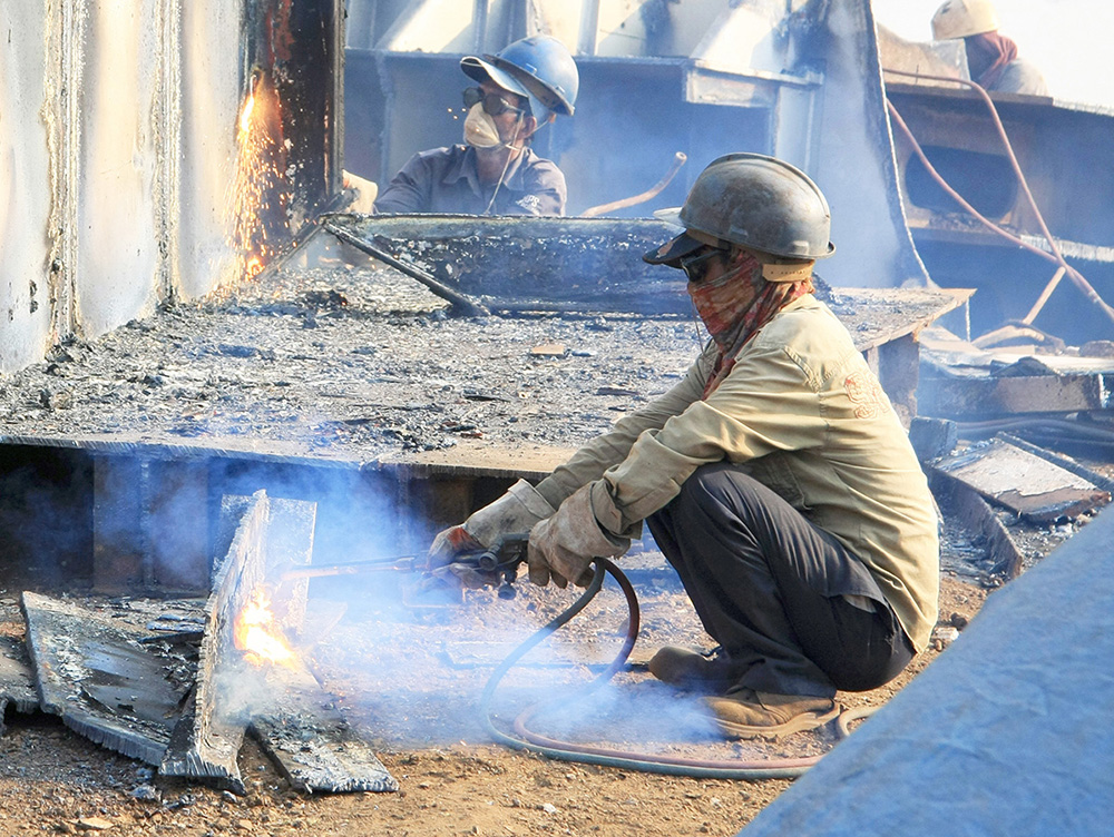 construction worker squatting in dusty field
