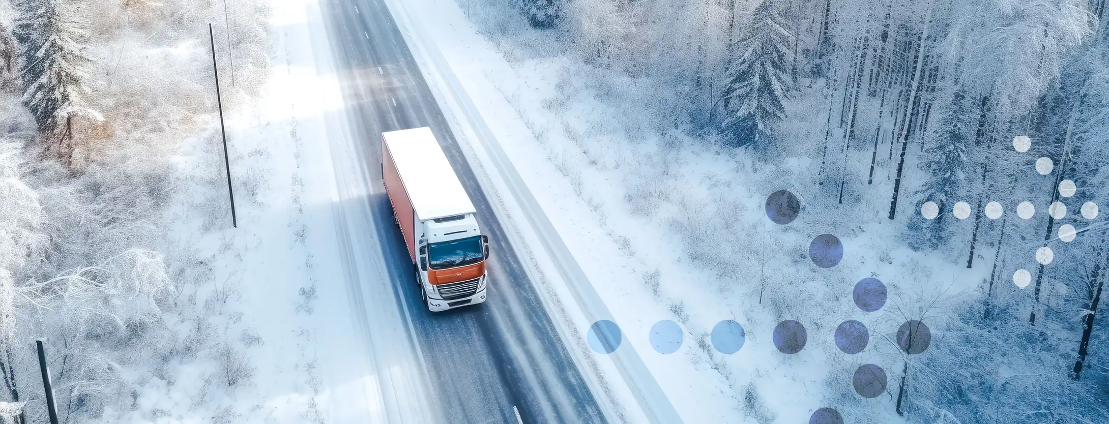 Aerial view of truck moving along snow covered highway